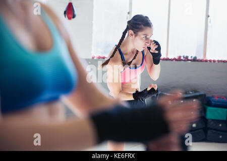 Entschlossener junger Boxer Schattenboxen im Fitnessstudio Stockfoto