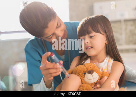 Weibliche Krankenschwester Lehre Mädchen Patientin mit Teddybär wie man Insulin-Stift verwenden Stockfoto