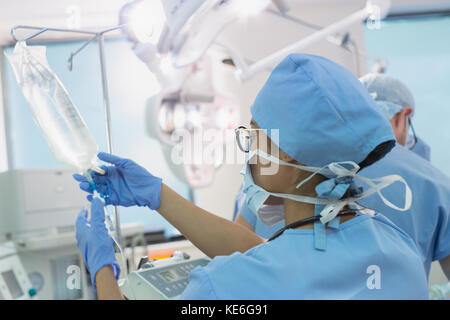 Weibliche Anästhesistin bereitet Infusionströpfchen im Operationssaal vor Stockfoto