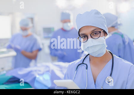 Portrait zuversichtlich weibliche Chirurg trägt chirurgische Maske im Operationssaal Stockfoto