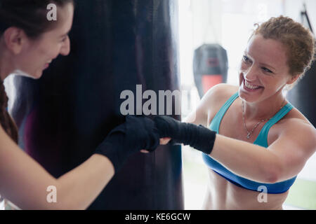 Lächelnd weibliche Boxer Faust stoßen im Fitnessstudio Stockfoto