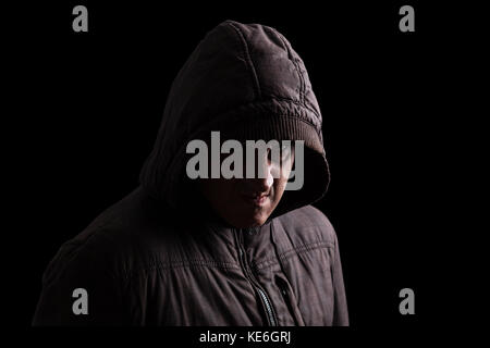 Mann mit unterdrückte Wut und gewaltsamen Instinkt versteckt im Schatten. Stand in der Dunkelheit/wütend passive aggressive aufgebrachten Wut Wut wilde Stockfoto