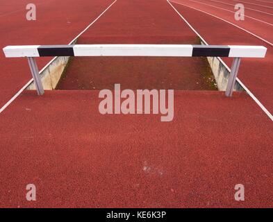 Hohe Hürde. Hürde Titel running Lane. Holz- Hürde auf rot High School Schiene Stockfoto