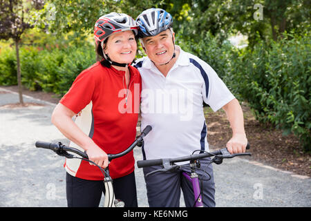 Portrait von Gerne ältere Paare mit ihren Fahrrädern Stockfoto