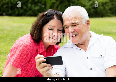 Gerne älteres Paar unter Selfie mit Handy Stockfoto