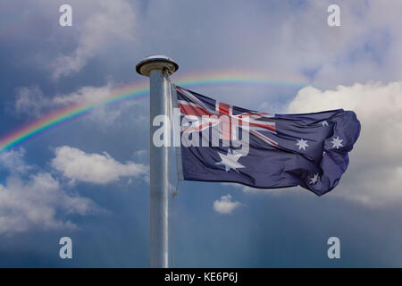 Australische Flagge an einem Mast mit Regenbogen in den Himmel. Patriotismus Konzept Stockfoto