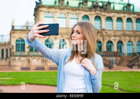 Mädchen macht Fotos Aufnahmen der europäischen Stadt Dresden und selfie Hintergrund alte deutsche Stadt Stockfoto