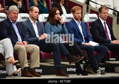 Sir Keith Mills (links), Vorsitzender der Royal Foundation, sitzt zusammen mit dem Herzog und der Herzogin von Cambridge und Prinz Harry im Londoner Stadion von West Ham United, während sie an der Abschlussfeier für mehr als 150 Trainerlehrlinge teilnehmen. Stockfoto