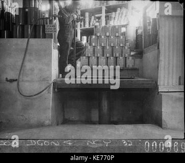 13582 Arbeiter stapeln eine Palette von Sprühdosen im Fahrstuhl Stockfoto