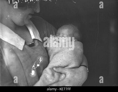 42686 Baby John haywood in den Armen einer Krankenschwester Stockfoto