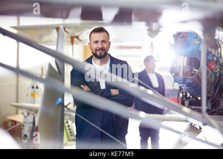 Portrait zuversichtlich männlichen Flugzeug Mechaniker am Flugzeug im Hangar Stockfoto