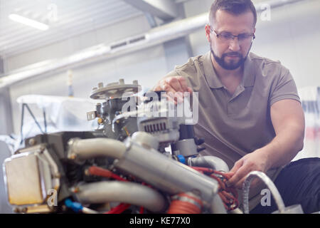 Männliche Mechaniker zur Befestigung des Motors Stockfoto