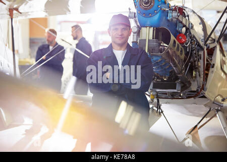 Portrait zuversichtlich männliche Mechaniker arbeiten am Flugzeug im Hangar Stockfoto