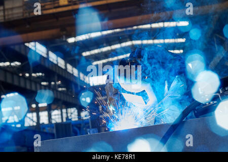 Schweißer in Schweißmaske Schweißen Stahl im Werk Stockfoto