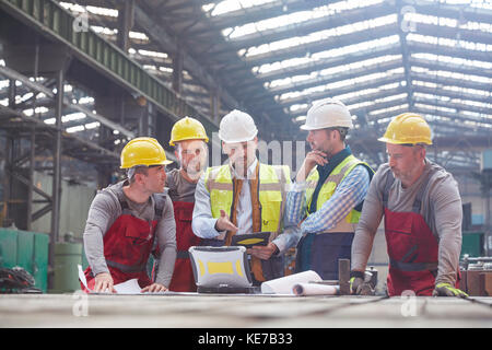 Männlicher Vorarbeiter, Ingenieure und Arbeiter treffen sich in der Fabrik Stockfoto