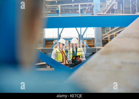 Männliche Ingenieure, die im Werk digitale Tablets verwenden Stockfoto