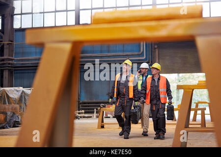 Männliche Arbeiter gehen in der Stahlfabrik Stockfoto