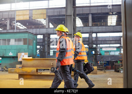 Männliche Arbeiter gehen in der Stahlfabrik Stockfoto