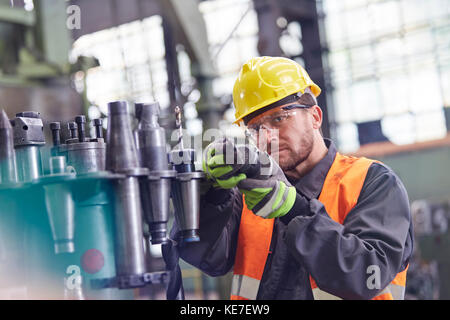 Männlicher Arbeiter, der Stahlteile in der Fabrik untersucht Stockfoto