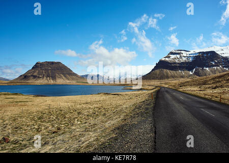 Eine asphaltierte Straße entlang der Küste mit Snow-Capped Berge, die Halbinsel Snaefellsnes ; Island Stockfoto