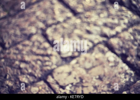 Verschwommene Nahaufnahme Bild vom alten gepflasterten Straße bei Nacht, Farbe Tonen angewendet, abstrakten Hintergrund. Stockfoto