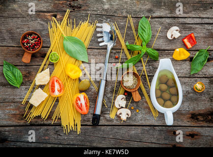 Die Zutaten für hausgemachte Pasta Basilikum, Parmesan, Knoblauch, Olivenöl, Pfeffer, Pilz auf schäbige Holz- Hintergrund mit Flach. Stockfoto