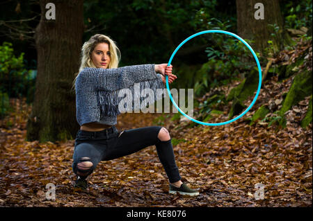 Mädchen schaut direkt in die Kamera, geduckt, heraus halten, einen Reifen zu Ihrer Seite, im Wald Posing, kopieren. Stockfoto