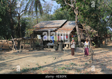 Das Dorf Nyaunghtaw liegt am linken (östlichen) Ufer des Irrawaddy River in der Provinz Ayeyarwaddy in Myanmar (Birma). Frau, die Handyfotos von Touristen macht. Stockfoto