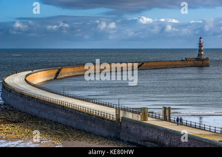 Eine gekrümmte Pier, die zu Roker pier Leuchtturm; Sunderland, Tyne und Wear, England Stockfoto