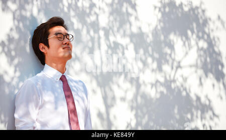 Portrait von Geschäftsmann entspannend lehnte sich gegen eine Wand. Stockfoto