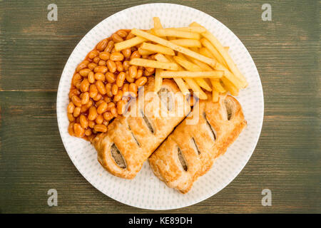 Würstchen, Brötchen mit Baked Beans Chips und Pommes Frites vor einem grünen Hintergrund Holz Stockfoto