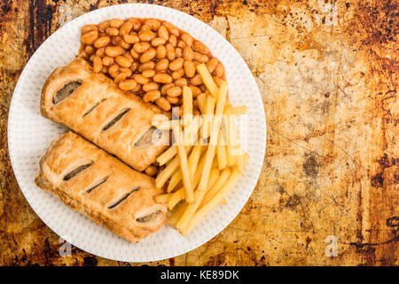 Würstchen, Brötchen mit Baked Beans Chips und Pommes frites auf einem distressed Backofen oder Backblech mit Kopie Raum Stockfoto