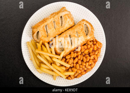 Würstchen, Brötchen mit Baked Beans Chips und Pommes frites auf schwarzem Hintergrund Stockfoto