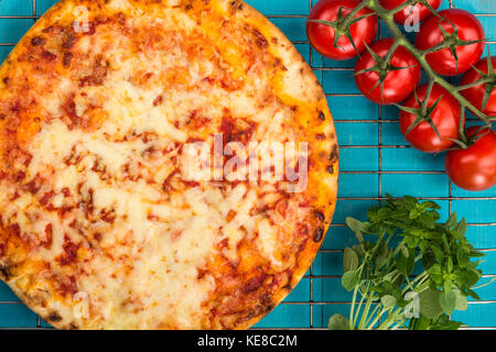 Im italienischen Stil stonebaked Mozzarella und Tomate margarita Pizza auf einem blauen Hintergrund aus Holz Stockfoto