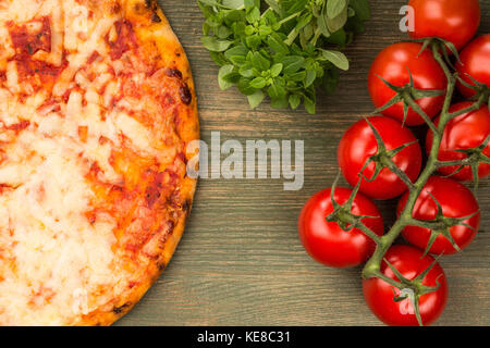 Im italienischen Stil stonebaked Mozzarella und Tomate margarita Pizza auf einem grünen Holz- Hintergrund Stockfoto