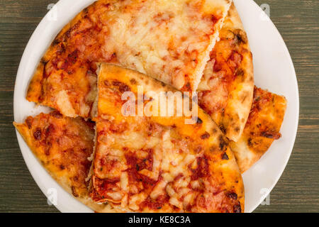 Im italienischen Stil stonebaked Mozzarella und Tomate margarita Pizza auf einem grünen Holz- Hintergrund Stockfoto