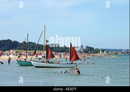 Familien Bade- und auf Studland Bay Beach, Branksea Schloss auf der Insel Brownsea im Hintergrund, Dorset, England Stockfoto