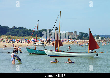 Familien Bade- und auf Studland Bay Beach, Branksea Schloss auf der Insel Brownsea im Hintergrund, Dorset, England Stockfoto