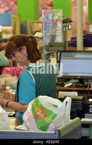 Eine Frau oder eine Frau arbeiten an den Kassen zu einem großen Supermarkt an der Kasse und till Geld und Karten aus dem Kunden einkaufen Essen Stockfoto