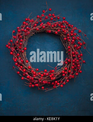 Weihnachten Kranz mit roten Beeren auf dem dunkelblauen Hintergrund Stockfoto