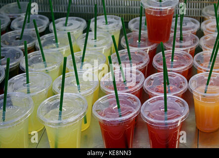 Frisch gepresste Fruchtsäfte in Plastikbechern am Markt veräußert werden. Stockfoto