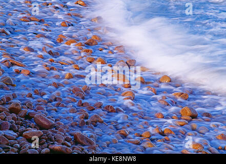 Kanal Inseln. Guernsey. Wellen auf Pebble Beach. Stockfoto