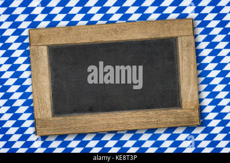 Leere Schiefertafel auf einem bayerischen Rautenmuster. Stockfoto