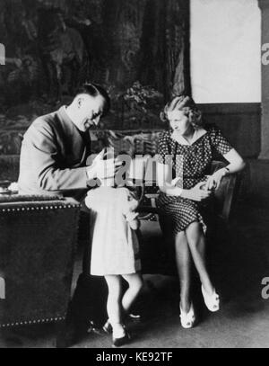 Reichskanzler Adolf Hitler und seine Gefährtin Eva Braun mit dem Mädchen Uschi in Hitlers Arbeitszimmer in Berchtesgaden. Undatiert | weltweite Nutzung Stockfoto