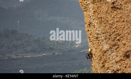 Gruppe von unscharfen männlichen Bergsteiger von einem Felsen hängenden Stockfoto