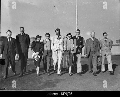 Auf dem Dach eines Stadtgebäudes ist eine Gruppe von Menschen zu sehen. Das Foto zeigt eine städtische Umgebung und zeigt sowohl die Menschen als auch die architektonischen Merkmale des Gebäudes während der Zeit. Stockfoto