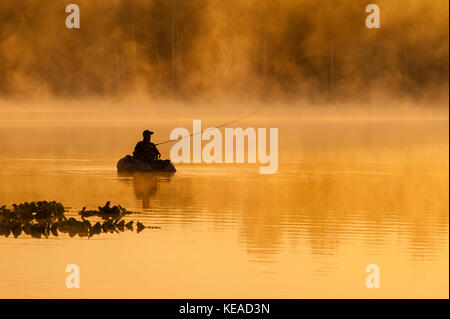 Fischer auf See Cassidy casting seine Linie earlysunre und Morgennebel Stockfoto