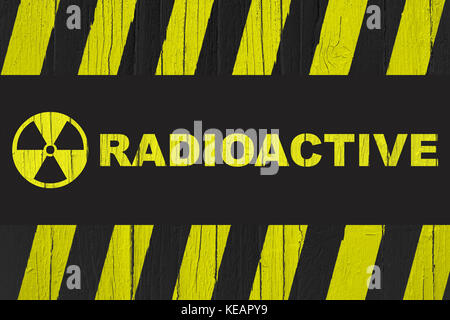 Radioaktive Warnschild mit gelben und schwarzen Streifen über Risse im Holz Textur Hintergrund gemalt. Stockfoto