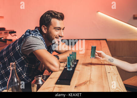 Barkeeper mit Alkohol Schüsse auf Zähler Stockfoto