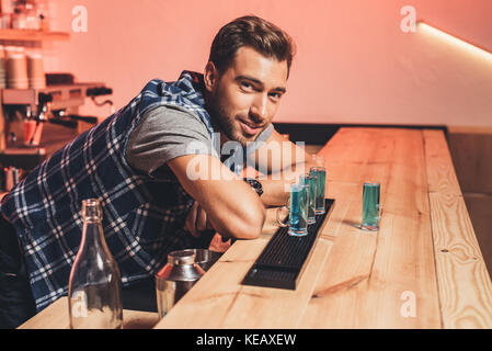 Barkeeper mit Alkohol Schüsse auf Zähler Stockfoto